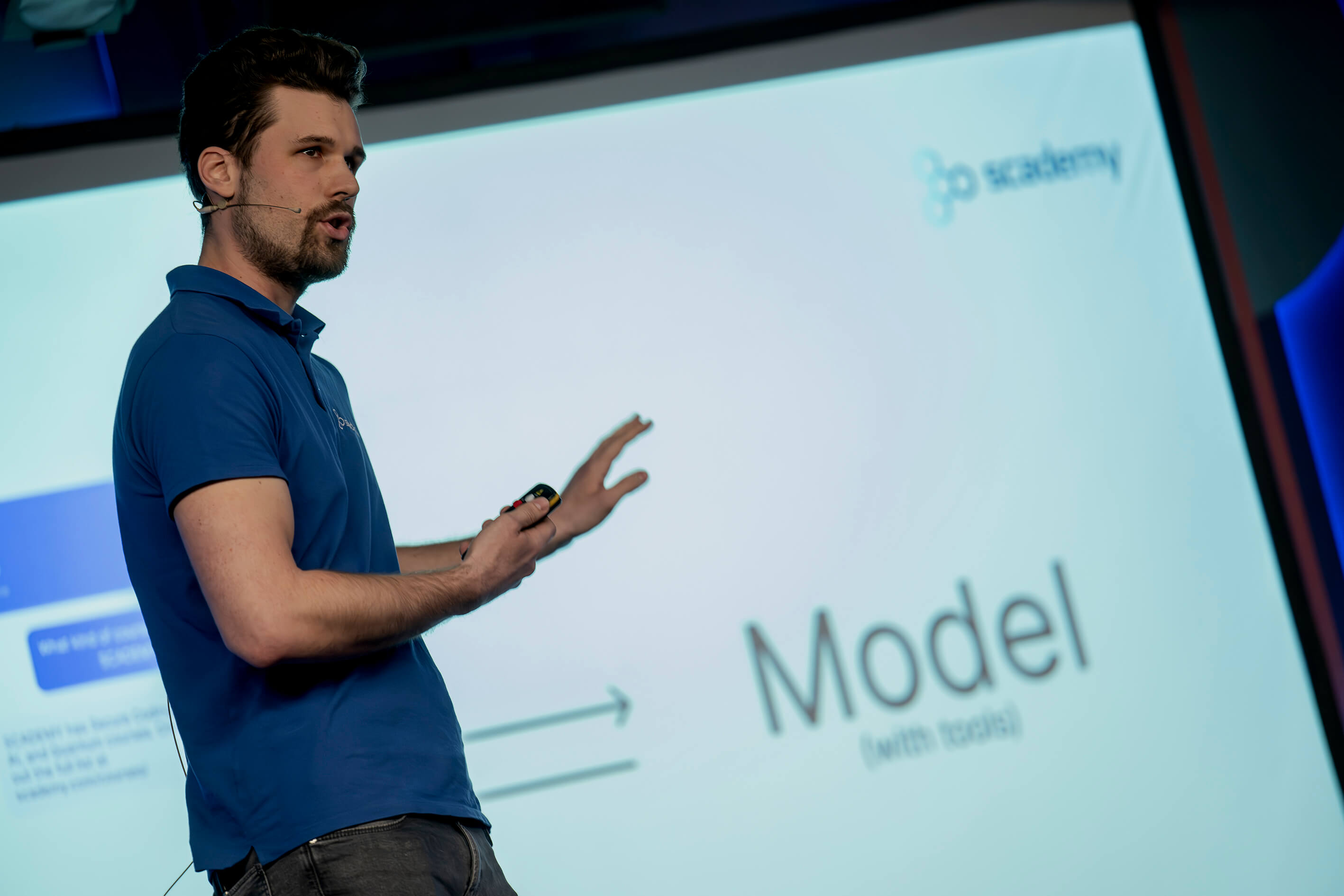 Speaker presenting AI model architecture at a tech conference